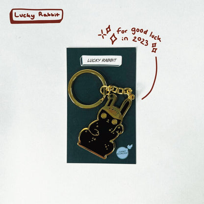 Gold hard enamel keychain on a backing card with "Lucky Rabbit" text