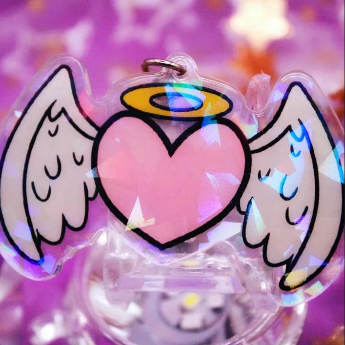 A heart shaped acrylic charm with stars and hearts on it.